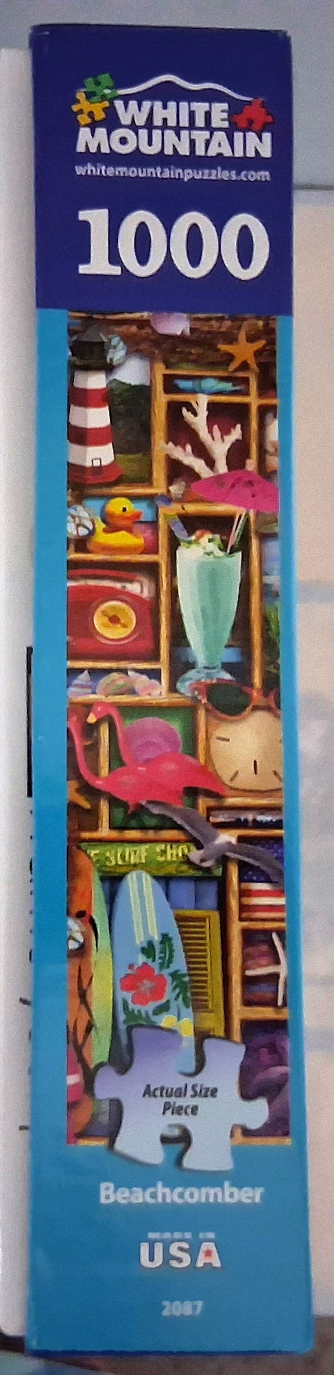 White Mountain 1000-piece jigsaw puzzle box featuring a colorful beachcomber illustration on a blue background.