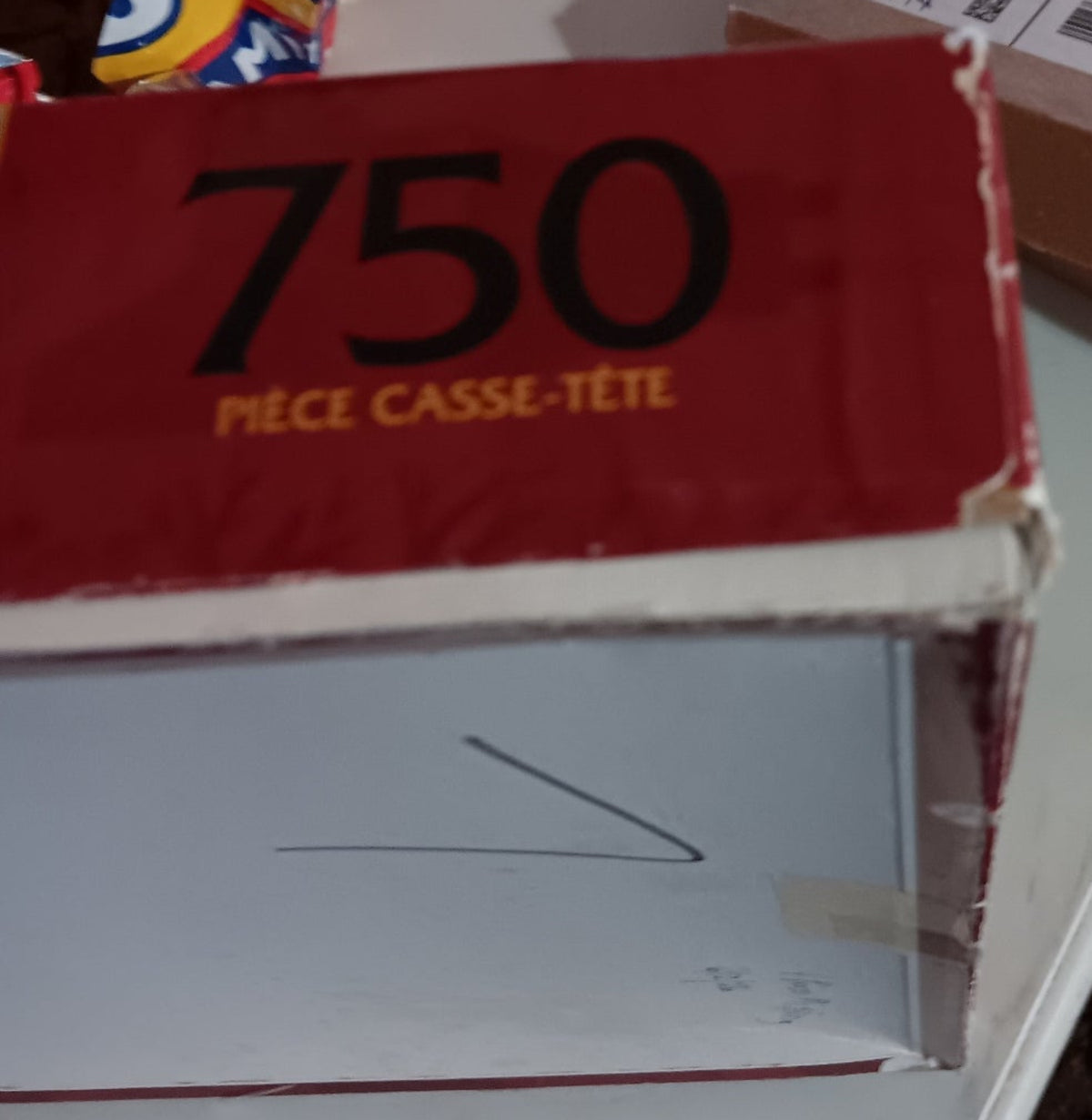 A red puzzle box  showing the back and one corner. 