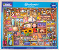 White Mountain Beachcomber 1000-piece jigsaw puzzle box featuring a colorful collage of beach-themed illustrations including starfish, seashells, sunflowers, a lighthouse, a sailboat, and beach accessories.