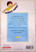 Back cover of a children's book titled 'Herbie Jones' by John Swetsen, published by Scholastic. The cover features a cartoon illustration of a boy with brown hair and a yellow shirt at the top, with the title in purple stylized text.