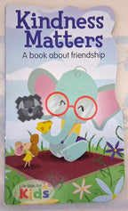 A children's book titled 'Kindness Matters: A book about friendship' with a colorful cartoon illustration of a light blue elephant wearing red glasses, sitting on a red blanket and sharing a yellow snack with a small mouse. The cover also shows the 'Life Skills for Kids' logo at the bottom left.