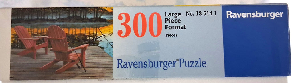 Ravensburger 300-piece jigsaw puzzle box featuring a lakeside scene with two red Adirondack chairs on a wooden deck, alongside text reading '300 Large Piece Format Pieces' and the Ravensburger brand.

