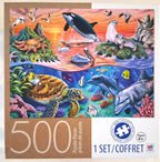 A 500-piece jigsaw puzzle box featuring a colorful ocean scene with dolphins, a sea turtle, seals, birds, and coral. The box shows '500 Puzzle Pieces', '1 SET/COFFRET', age 'Ages 8+', and the MB Puzzle Brand logo.