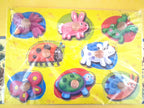 A children's wooden animal puzzle board with eight colorful animal cutouts on a bright yellow backing, photographed under clear plastic wrap.