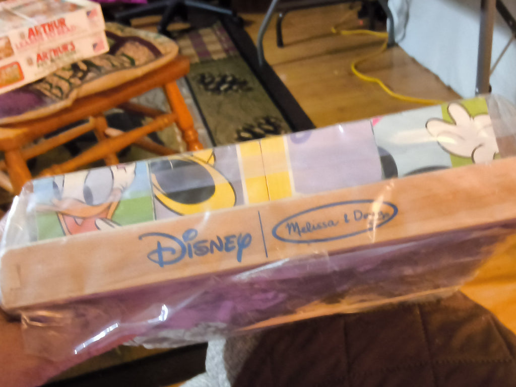 A packaged Melissa & Doug Disney wooden toy set in clear plastic wrapping. 