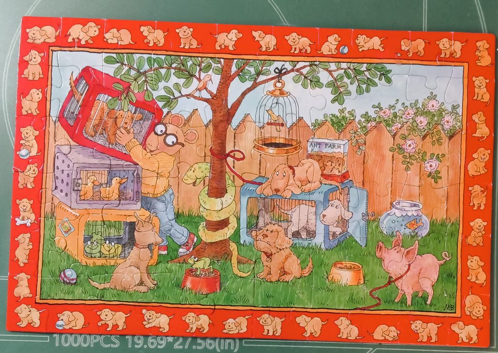 A completed 60-piece jigsaw puzzle featuring a whimsical cartoon scene of cats and dogs in a backyard with a tree, fence, and pet crates, bordered by small dog silhouettes. 